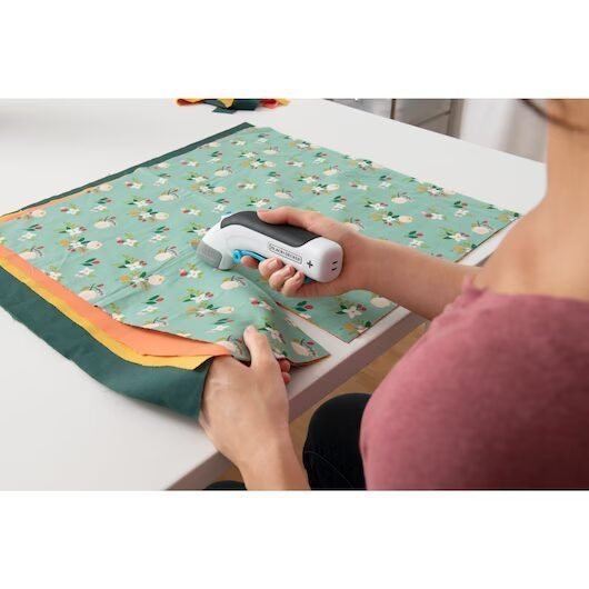 Cortadora eléctrica de tela sobre mesa blanca