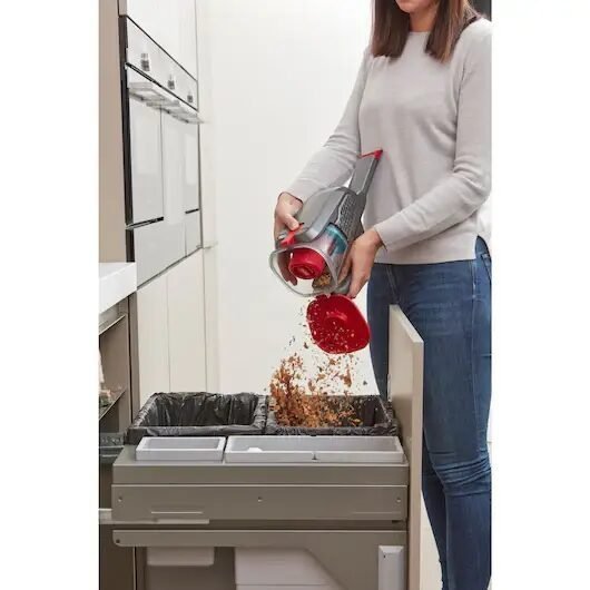 Vaciando aspiradora en el contenedor de basura.