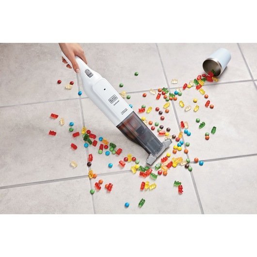 HLVC315B11_A6.jpg Aspiradora recogiendo caramelos en el suelo.