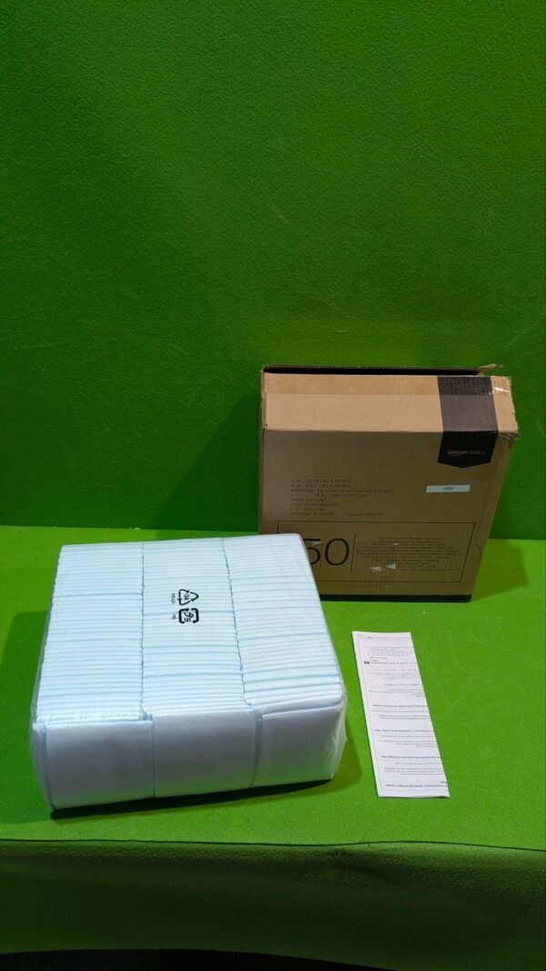 Caja y paquete de pañales sobre mesa verde.