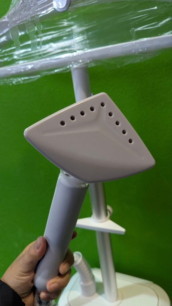 1000092515-scaled-1.jpg Plancha de vapor portátil sobre fondo verde.