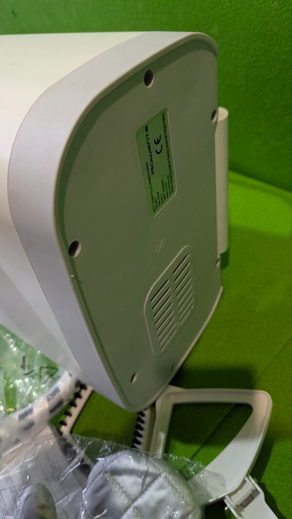 1000092516-scaled-1.jpg Base de plancha Rowenta sobre alfombra verde.