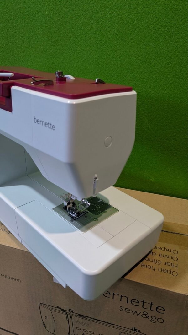 Máquina de coser Bernette sobre caja de cartón.