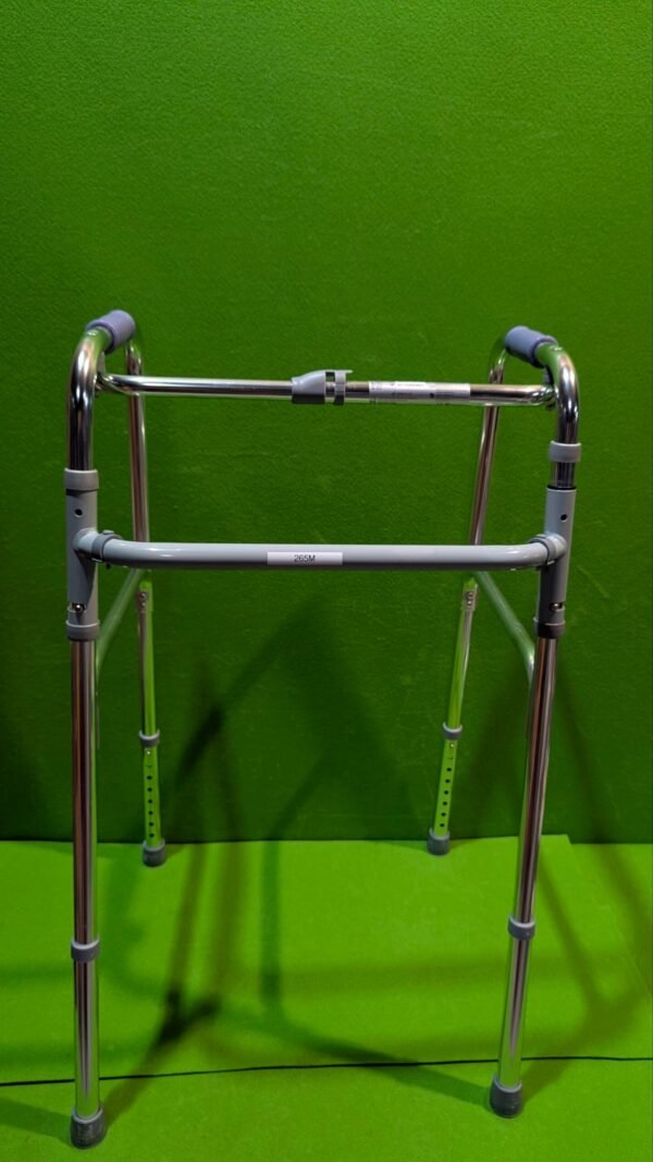 Andador metálico en fondo verde brillante.