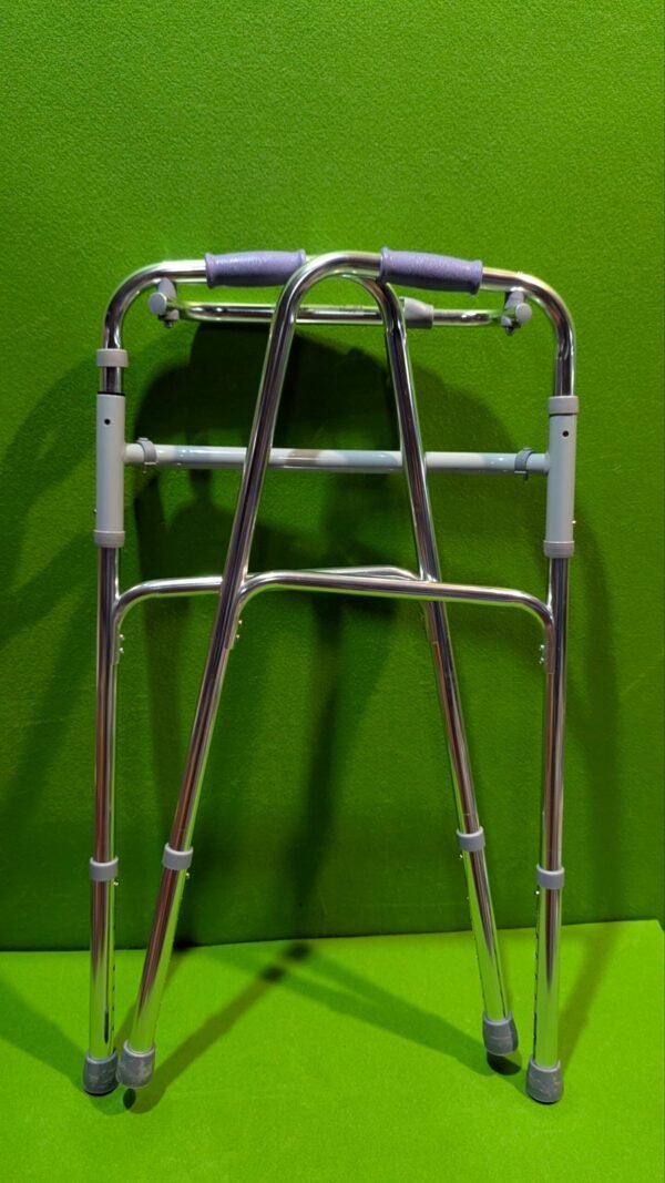 Andador metálico plegable sobre fondo verde.