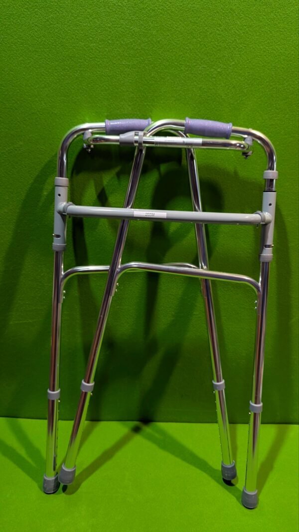 Andador plegable de aluminio sobre fondo verde