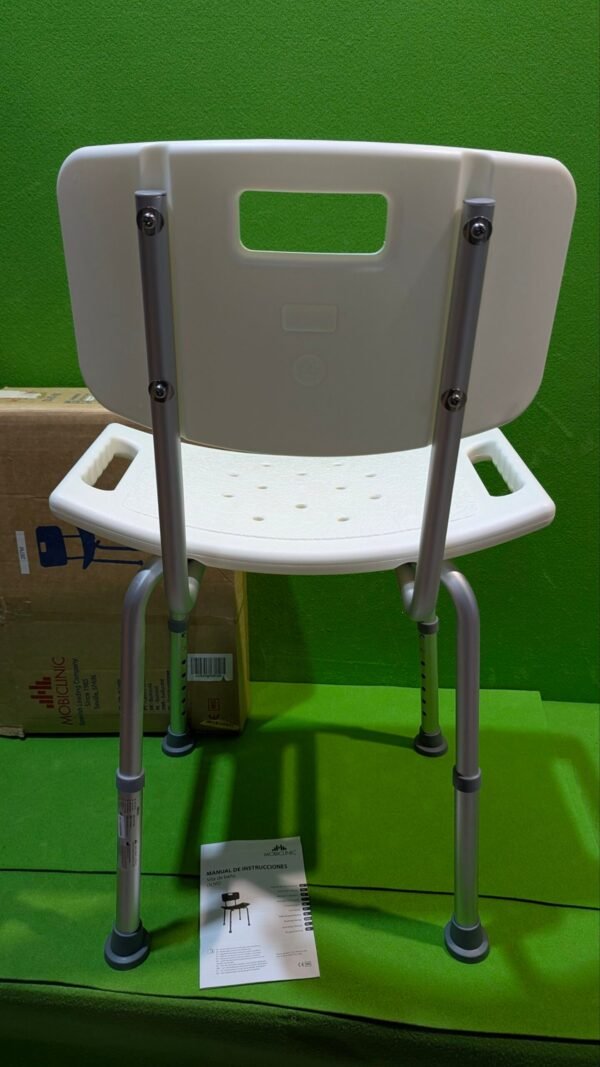 1000098469-scaled-1.jpg Silla de baño blanca sobre fondo verde.