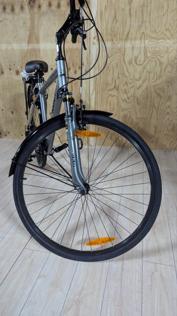 Bicicleta de ciudad con neumáticos negros y cuadro gris.