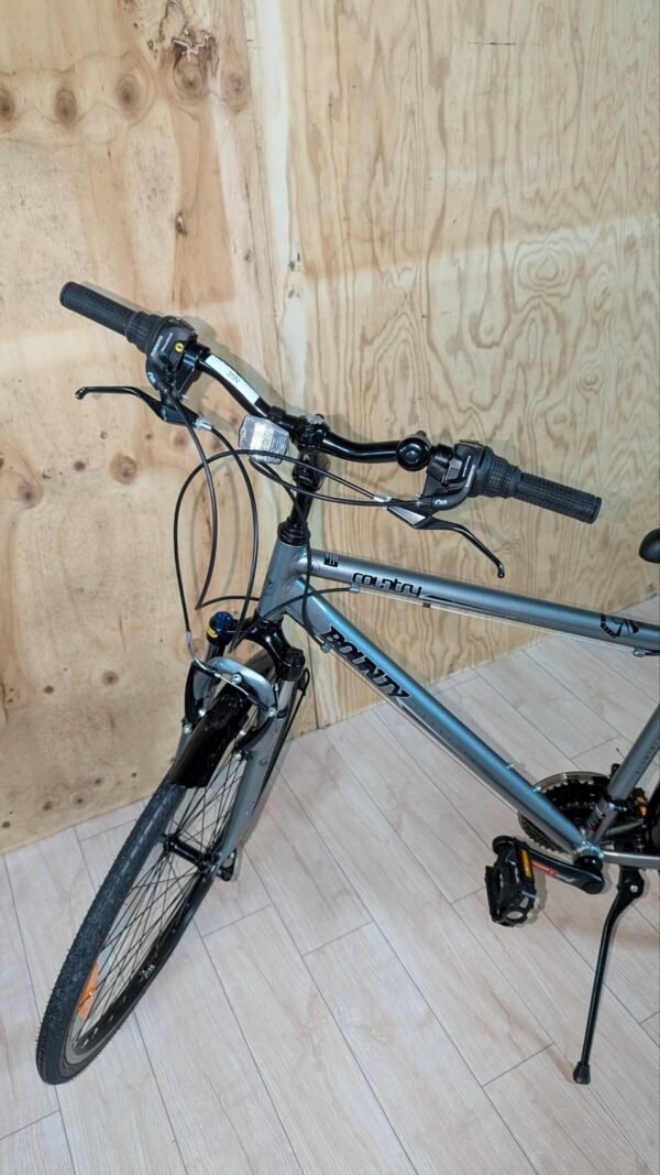 Bicicleta gris con manillar en habitación de madera.