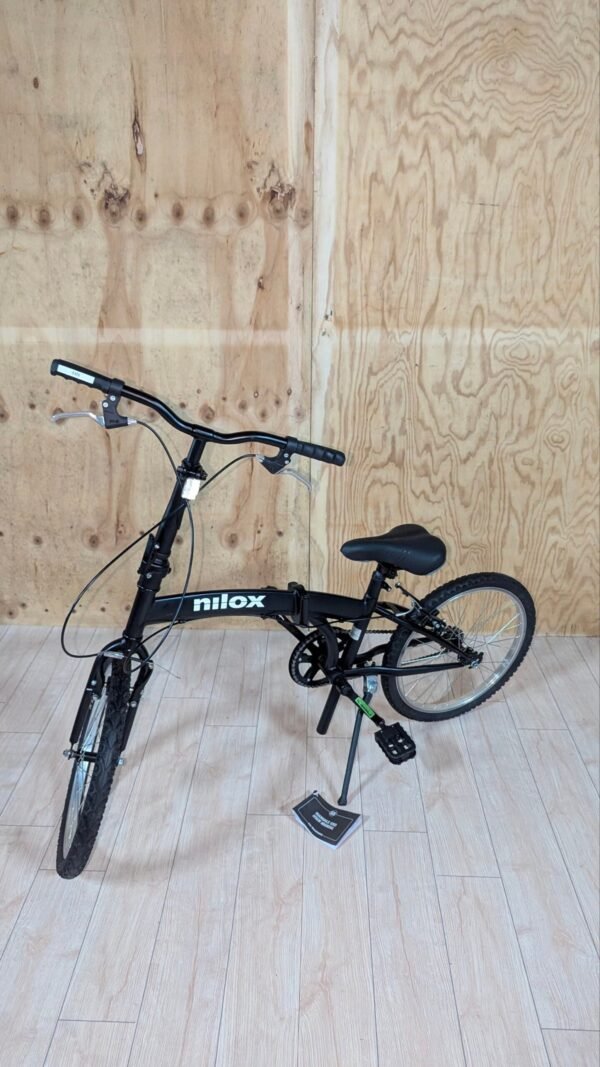 Bicicleta plegable negra en suelo de madera