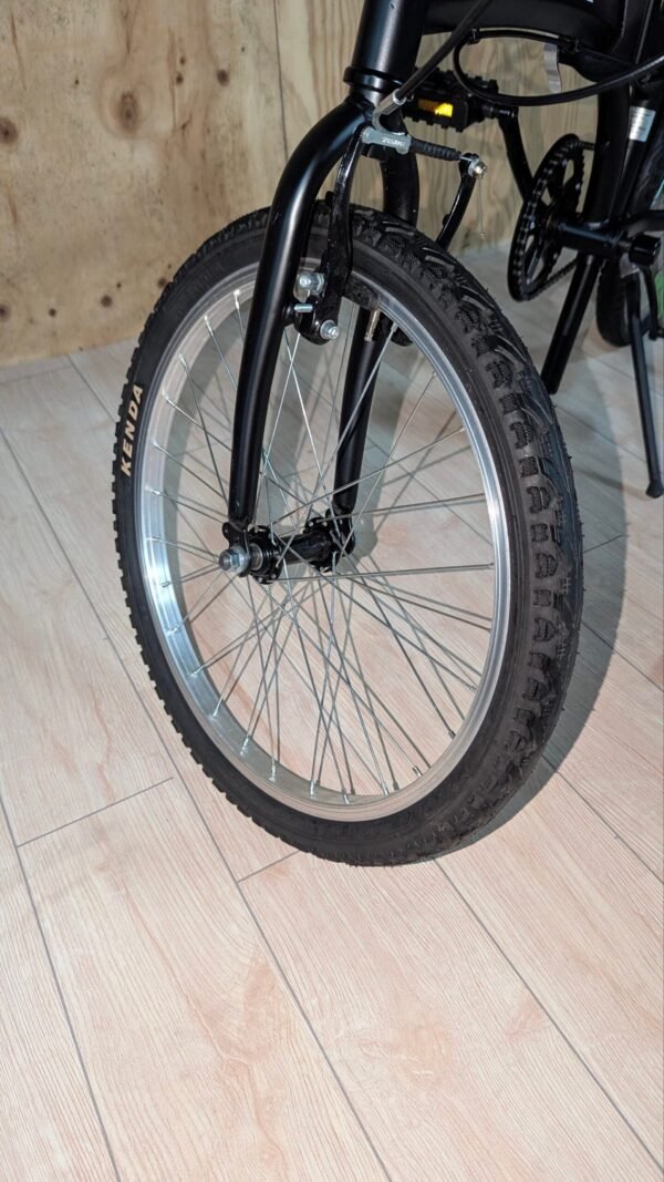 Rueda delantera de una bicicleta en suelo de madera.