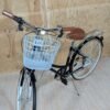 Bicicleta urbana con cesta sobre fondo de madera.