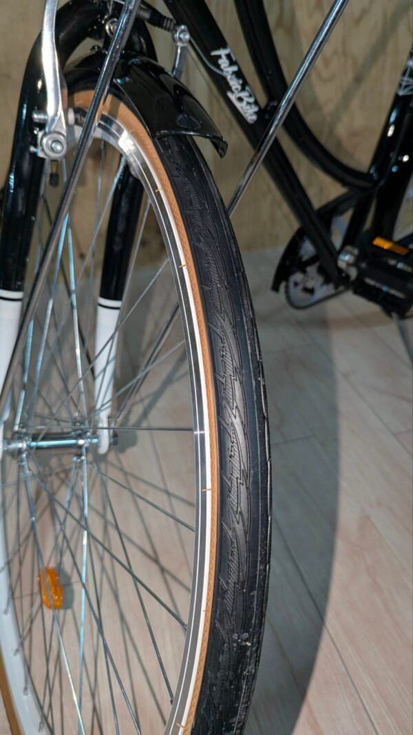 Rueda de bicicleta con guardabarros negro y neumático nuevo.