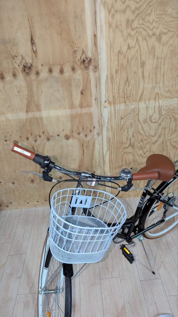 Bicicleta con cesta blanca en interior de madera.