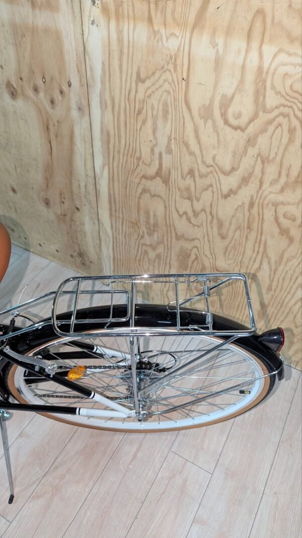 Bicicleta retro con portaequipajes en interior de madera.