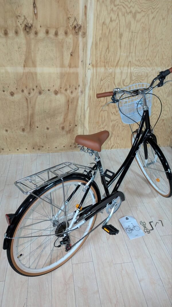 Bicicleta lista para ensamblar en suelo de madera.