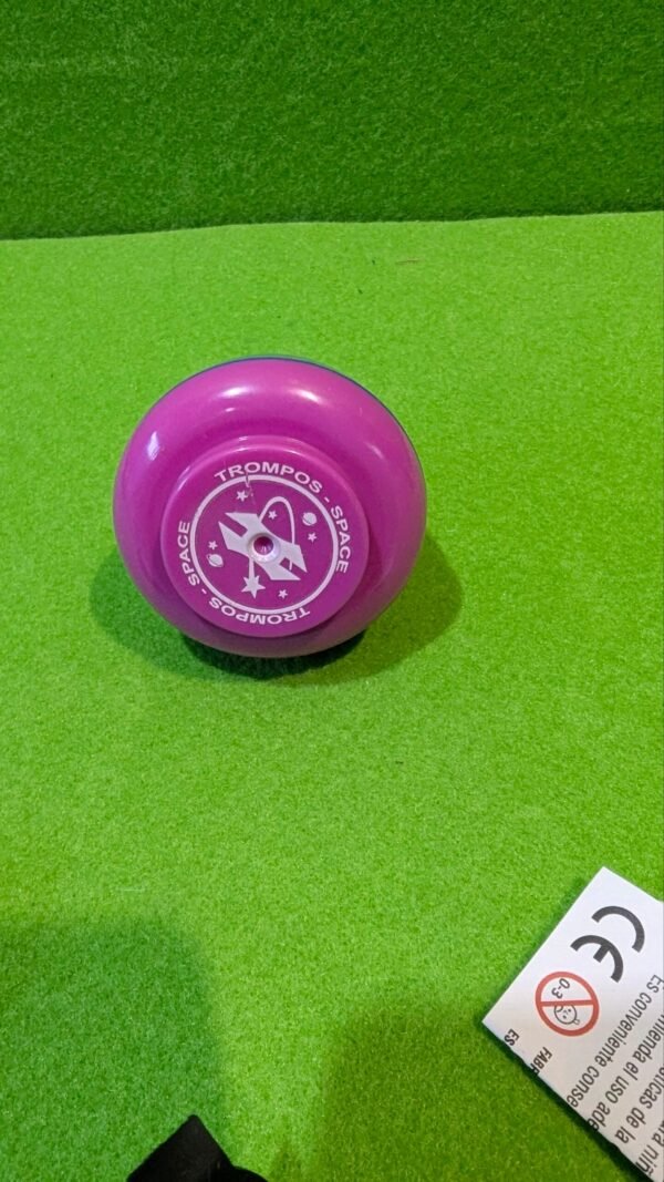 Peonza rosa Trompos Space sobre fondo verde