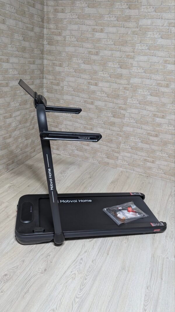 Cinta de correr negra Mobvoi en habitación moderna.