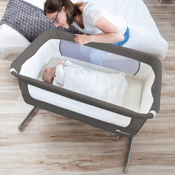 Bebé en cuna con madre sonriendo