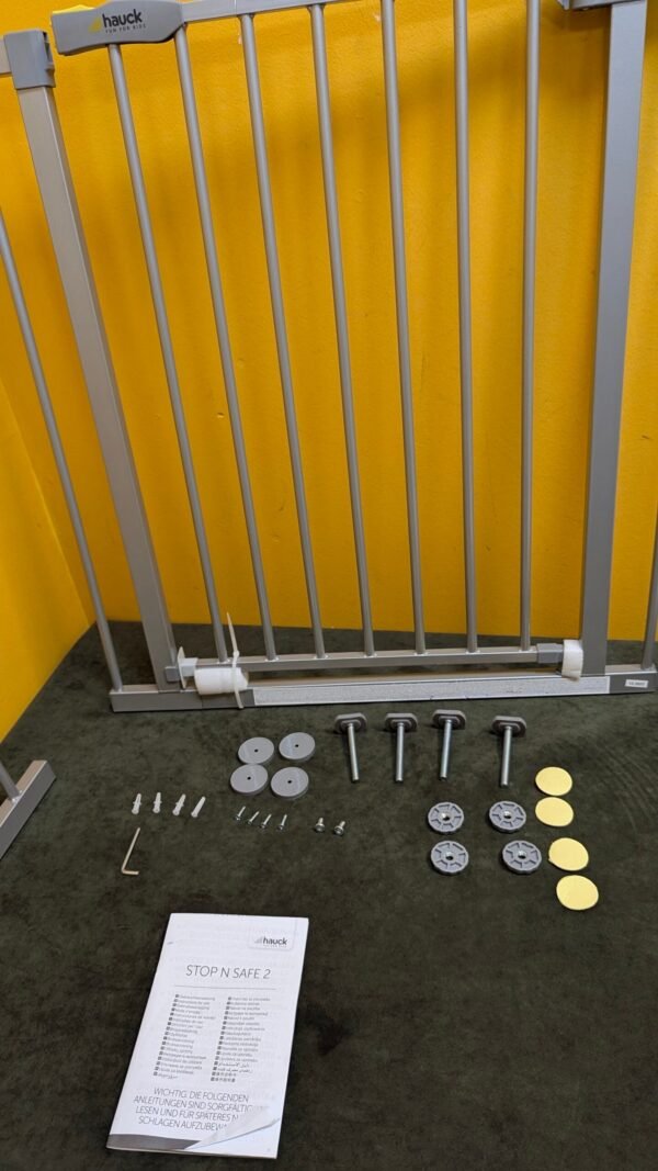 Puerta de seguridad infantil con manual y accesorios.