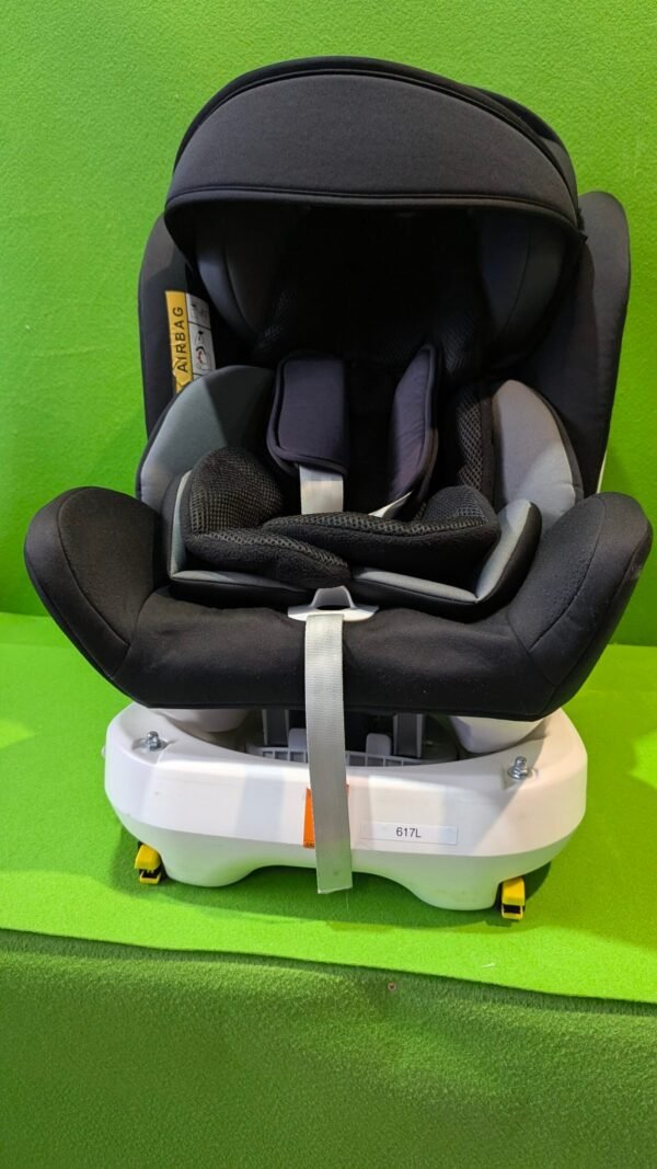 Silla de coche infantil negra sobre fondo verde