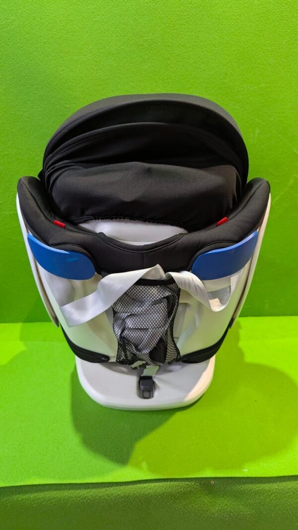 Silla de coche para bebé sobre fondo verde.