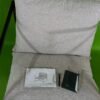 Silla beige con manual sobre alfombra verde.