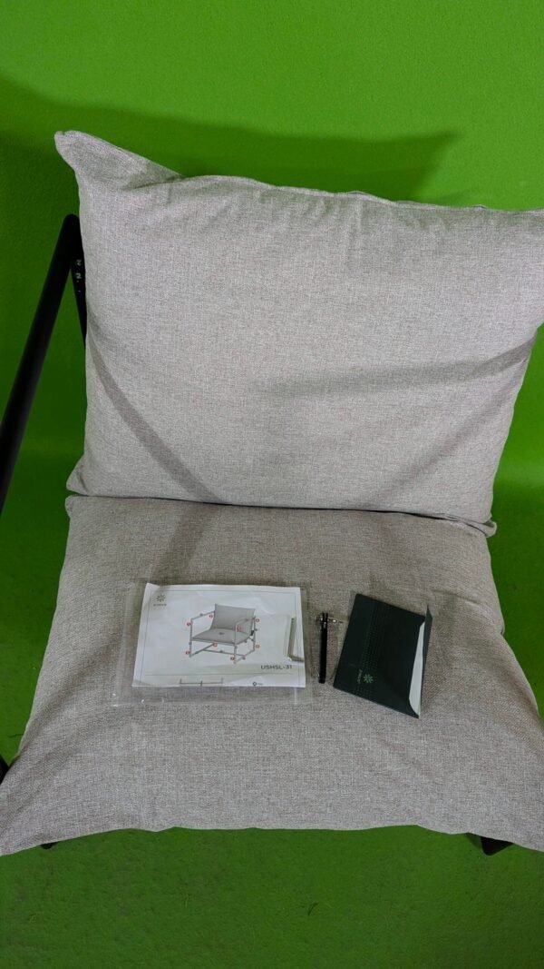 Silla beige con manual sobre alfombra verde.