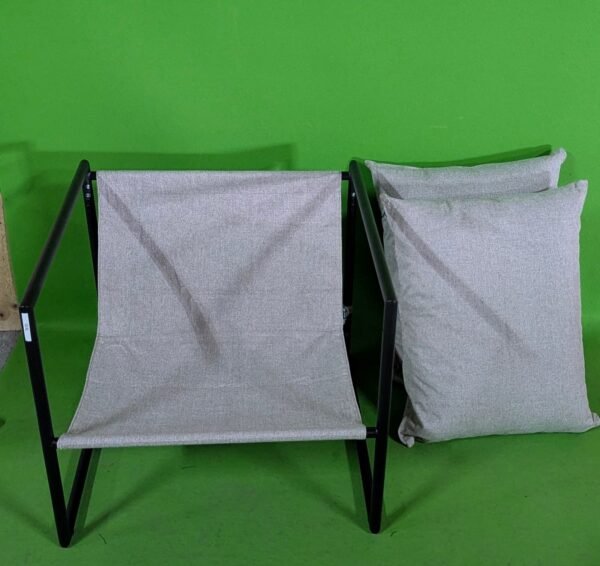 Silla y cojines grises sobre fondo verde brillante.