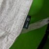 Etiqueta Zinus en tela beige sobre fondo verde.