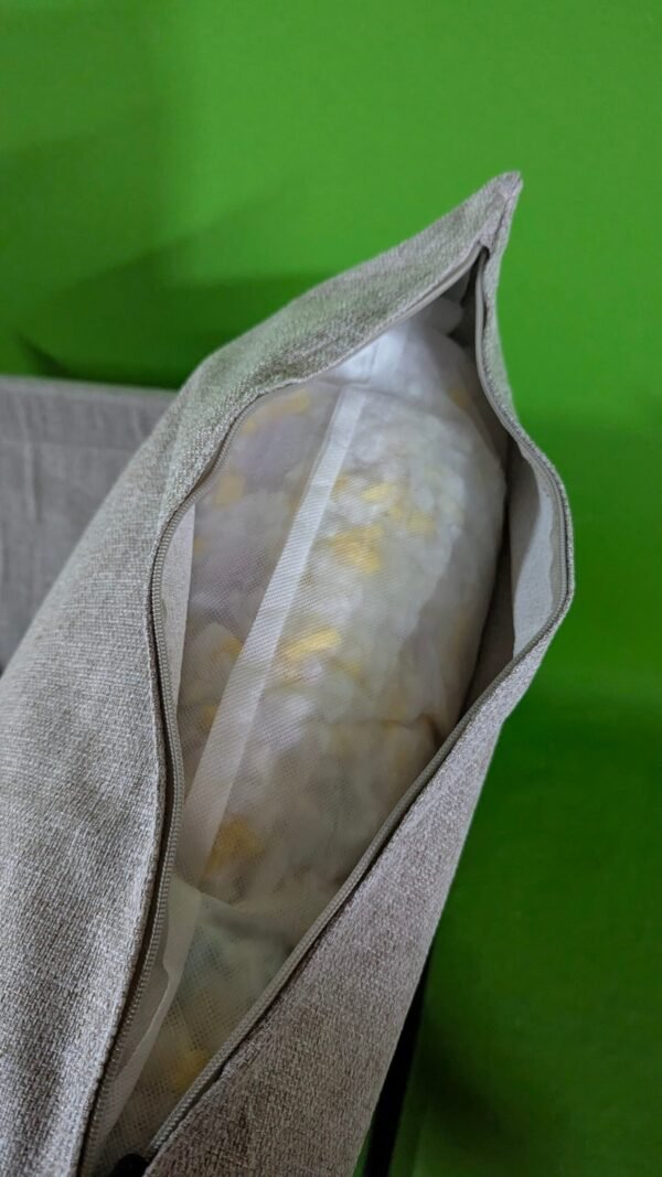 Interior de cojín beige con relleno visible.