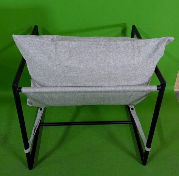 Silla moderna de metal con cojín beige. Vista trasera.