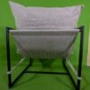 Silla moderna con armazón negro y cojín gris.