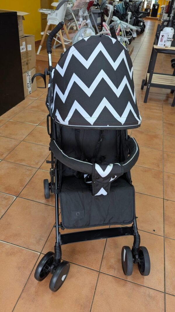 Cochecito negro con zigzags blancos en tienda.