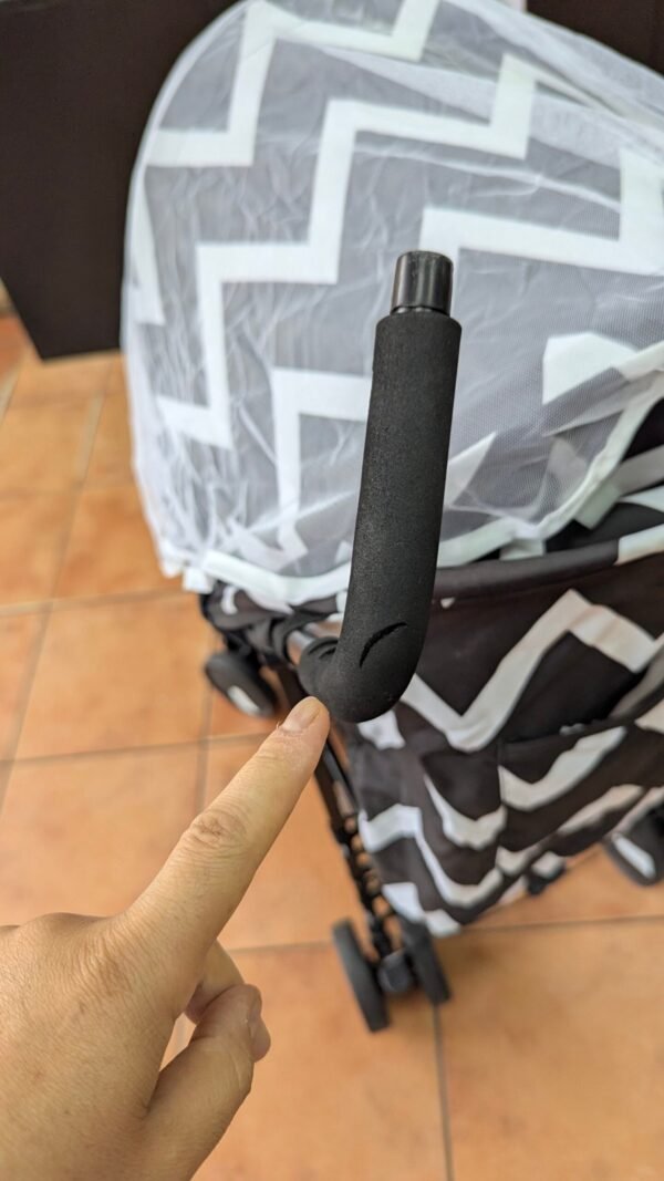 Mano señalando manilla de carrito de bebé