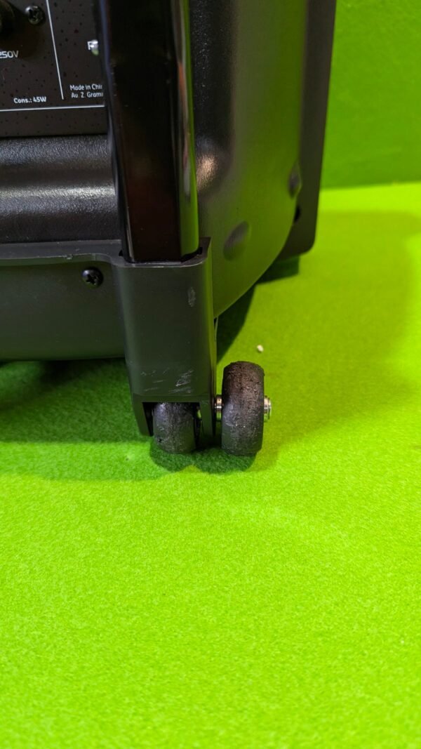 Ruedas de altavoz portátil sobre superficie verde