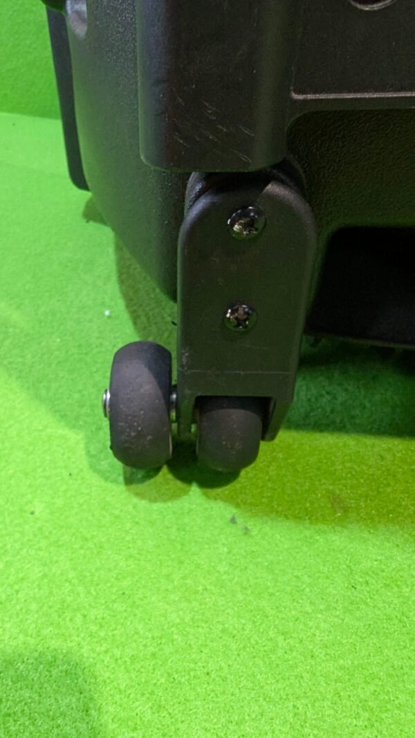 Rueda de maleta sobre alfombra verde