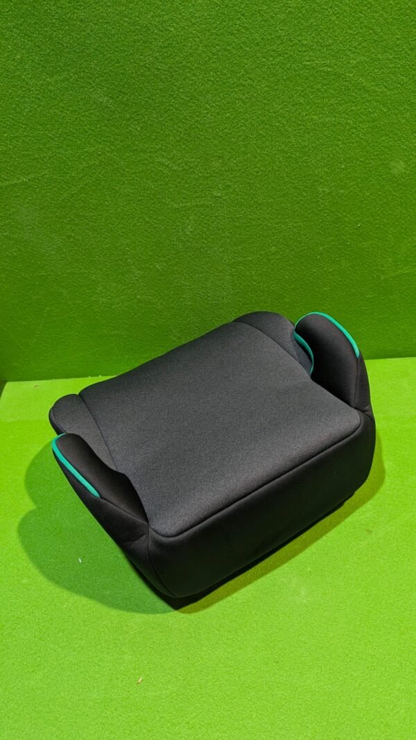 PXL_20251106_183458491-scaled-1.jpg Asiento elevador infantil negro sobre césped verde