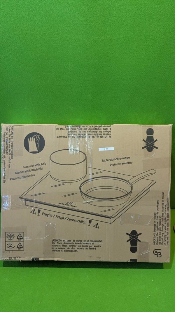 Caja de placa vitrocerámica sobre fondo verde.