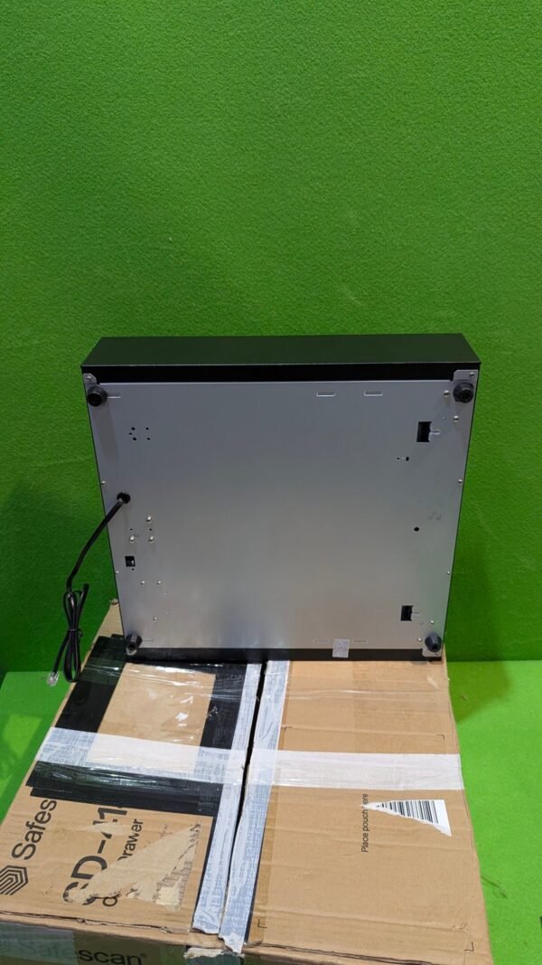 Parte trasera de microondas sobre caja Safescan.