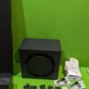 Subwoofer y accesorios sobre mesa verde