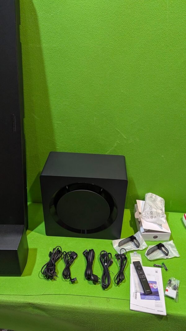 Subwoofer y accesorios sobre mesa verde
