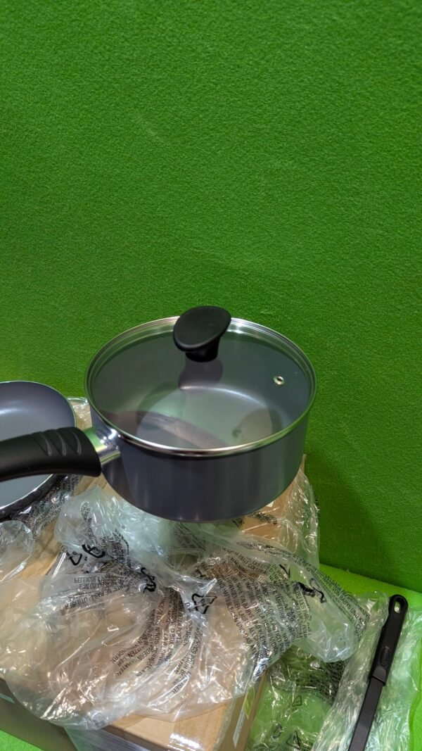 Cacerola con tapa sobre caja y envoltorio.