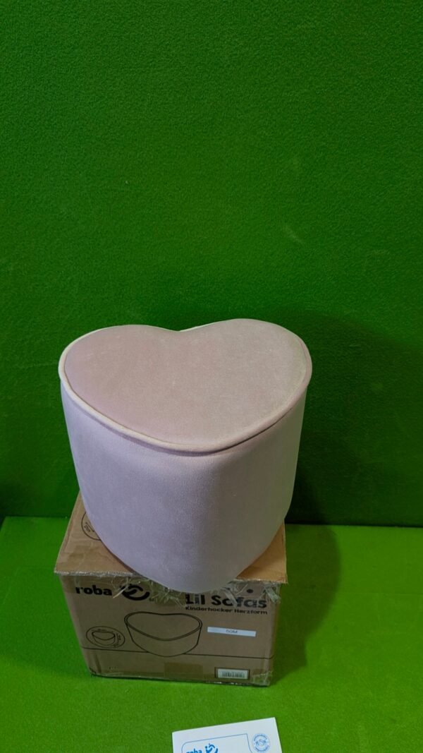 Puf rosa en forma de corazón sobre caja.