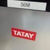Etiqueta roja con texto 'TATAY' y '56M'.