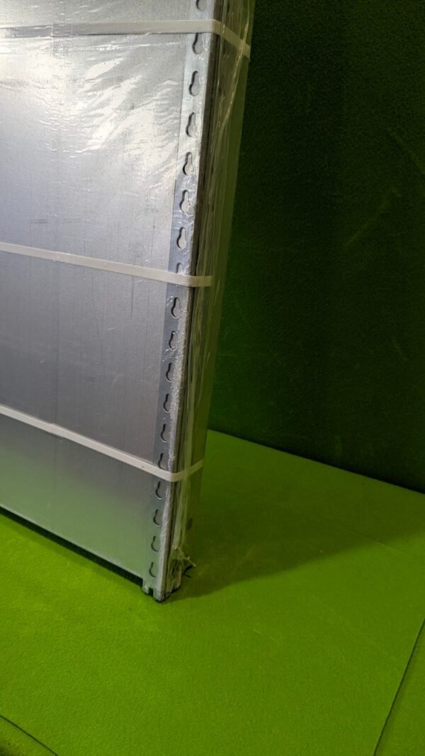 PXL_20251110_111603554-scaled-1.jpg Panel metálico embalado con cintas, fondo verde.