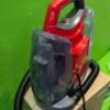 Aspiradora compacta roja sobre caja de cartón.
