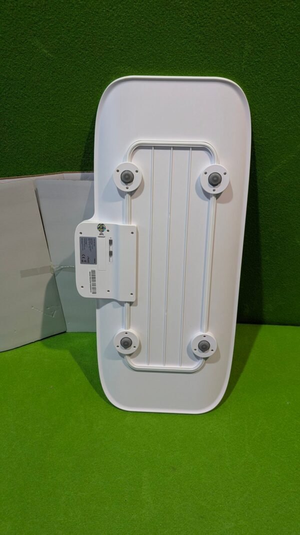 Parte trasera de panel blanco encima de césped verde.