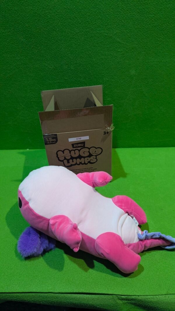 Peluche colorido junto a una caja de cartón.