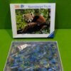 Caja de puzzle Ravensburger con panda rojo.